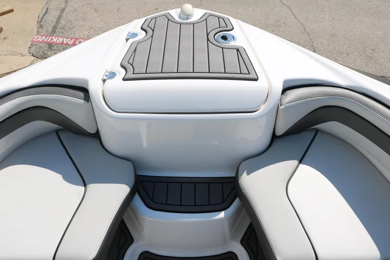 Slide: The Image of 2018 Yamaha Boats AR240 HO bow seating area with cushioned seats and storage. - 23