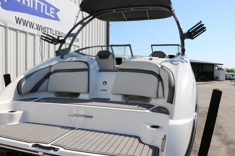 Slide: The Image of 2018 Yamaha Boats AR240 HO, rear view, docked, showcasing seating and swim platform. - 5