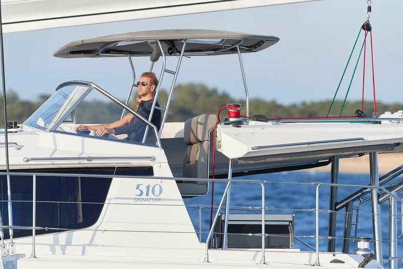 Slide: The Image of Man steering 2025 Privilege Signature 510 yacht on open water. - 25