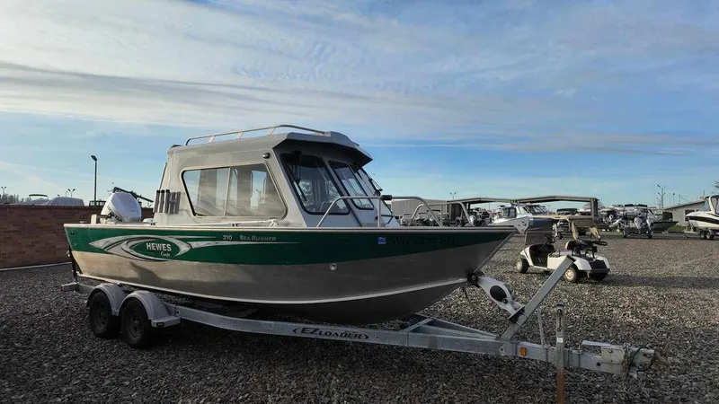 Slide: The Image of 2018 Hewescraft 210 Sea Runner boat on trailer, parked outdoors. - 1