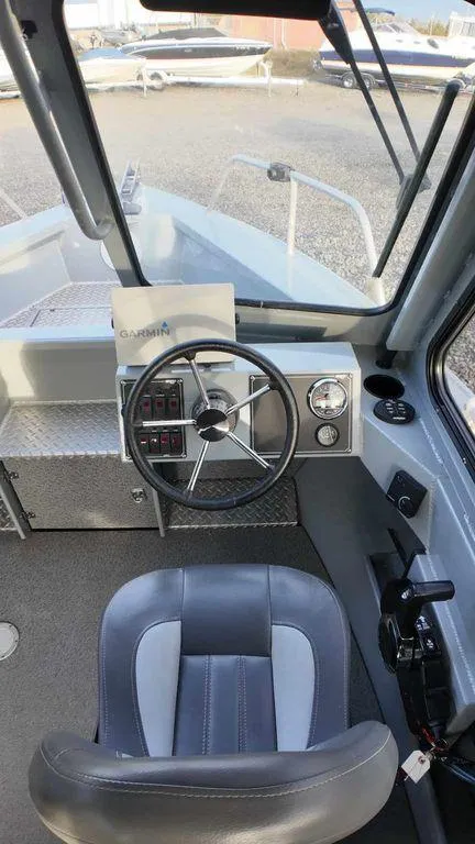 Slide: The Image of 2018 Hewescraft 210 Sea Runner boat interior with steering wheel and control panel. - 10