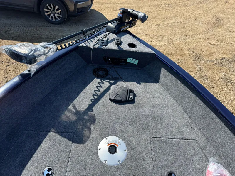 Slide: The Image of 2025 Tracker Pro Guide V-175 WT boat interior with trolling motor on a sandy surface. - 8