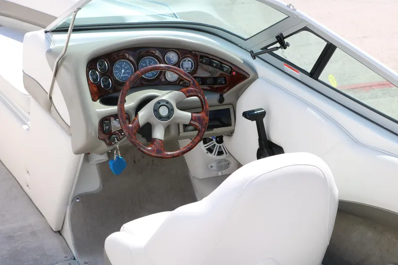 Slide: The Image of Interior of 2001 Crownline 225 BR boat, featuring steering wheel and dashboard controls. - 16