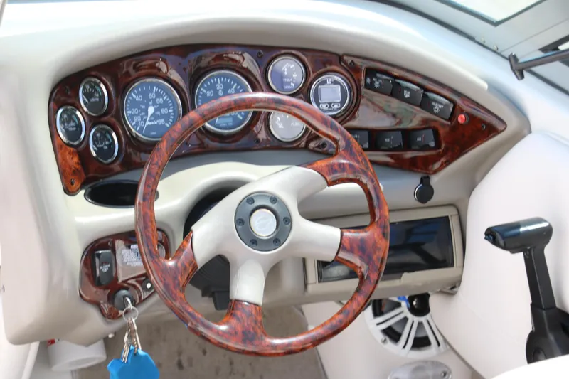 Slide: The Image of Dashboard of a 2001 Crownline 225 BR boat with woodgrain steering wheel and gauges. - 17