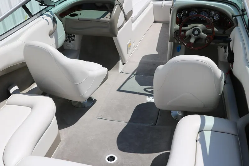 Slide: The Image of Interior of a 2001 Crownline 225 BR boat with white seating and steering wheel. - 19
