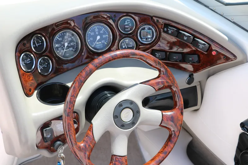 Slide: The Image of Dashboard of a 2001 Crownline 225 BR boat with woodgrain steering wheel and gauges. - 25