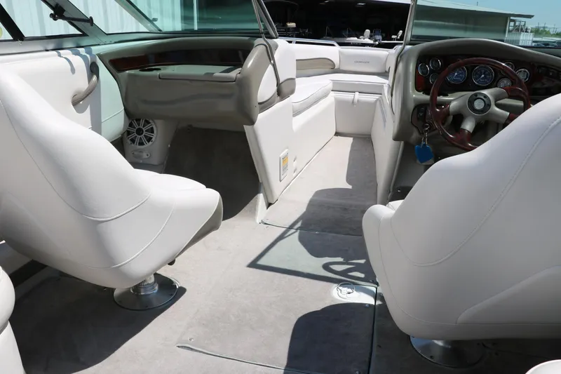 Slide: The Image of 2001 Crownline 225 BR boat interior with white seating and steering wheel. - 26