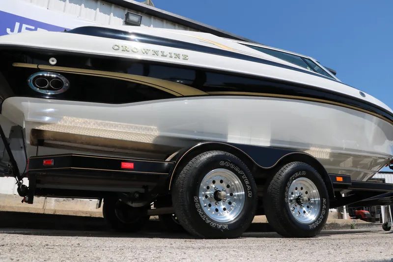 Slide: The Image of 2001 Crownline 225 BR boat on trailer, side view, showcasing sleek design and dual axles. - 3