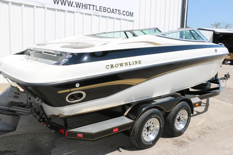 Slide: The Image of 2001 Crownline 225 BR boat on trailer, displayed outside Whittle Boats dealership. - 4