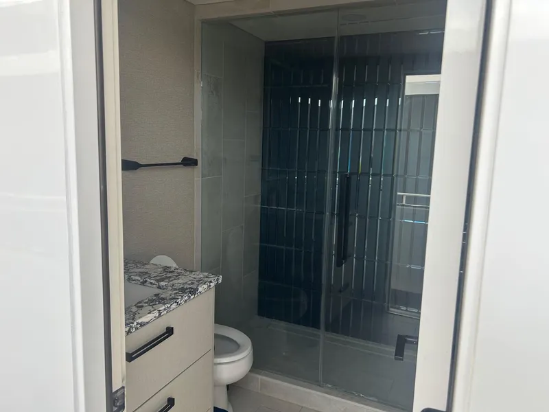 Slide: The Image of Modern bathroom with glass shower, granite countertop, and sleek cabinetry in Adonia Traditions 6 shares model. - 11