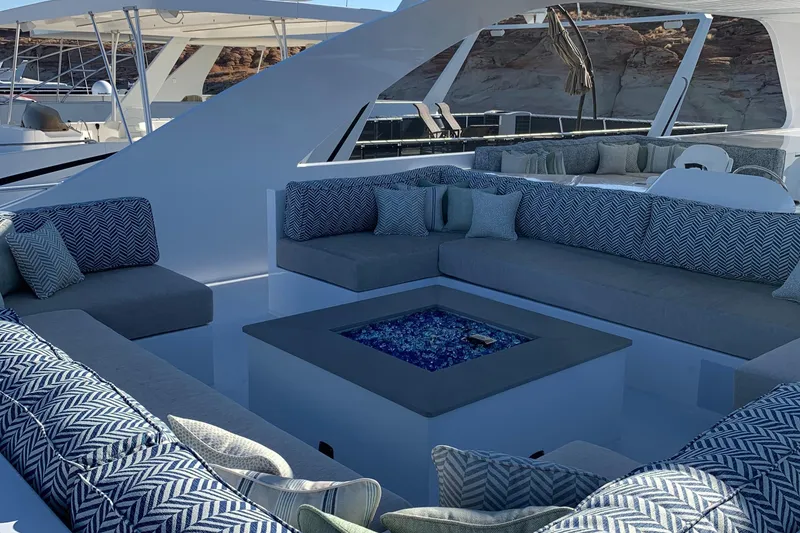 Slide: The Image of Luxurious Adonia Traditions 6 yacht lounge area with cushioned seating and central fire pit, 2020 model. - 19