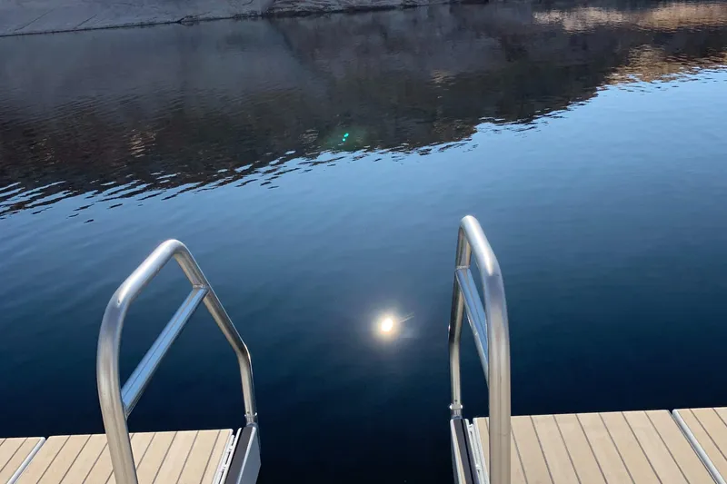 Slide: The Image of Dock ladder leading into calm water reflecting sunlight, Adonia Traditions 6 shares, 2020. - 20