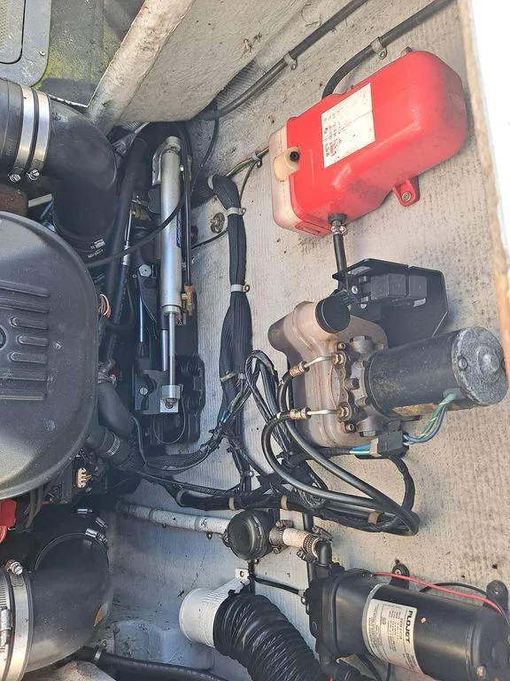 Slide: The Image of Engine compartment of a 2000 Osprey 26 Fisherman boat, showcasing mechanical components and wiring. - 10
