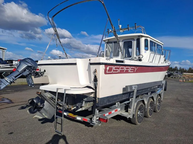 Slide: The Image of 2000 Osprey 26 Fisherman boat on trailer, clear sky background. - 15
