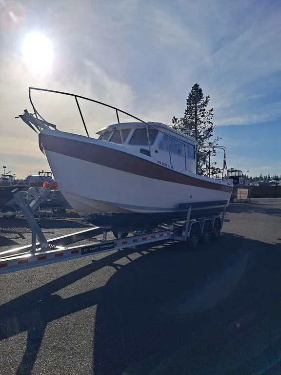 Slide: The Image of 2000 Osprey 26 Fisherman boat on trailer under bright sunlit sky. - 17