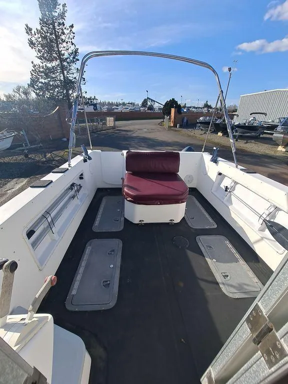 Slide: The Image of 2000 Osprey 26 Fisherman boat with maroon seating, spacious deck, and clear sky background. - 3