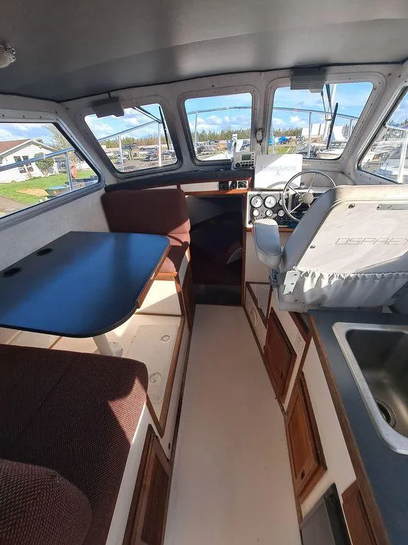 Slide: The Image of Interior of 2000 Osprey 26 Fisherman boat with seating, table, and steering console. - 6