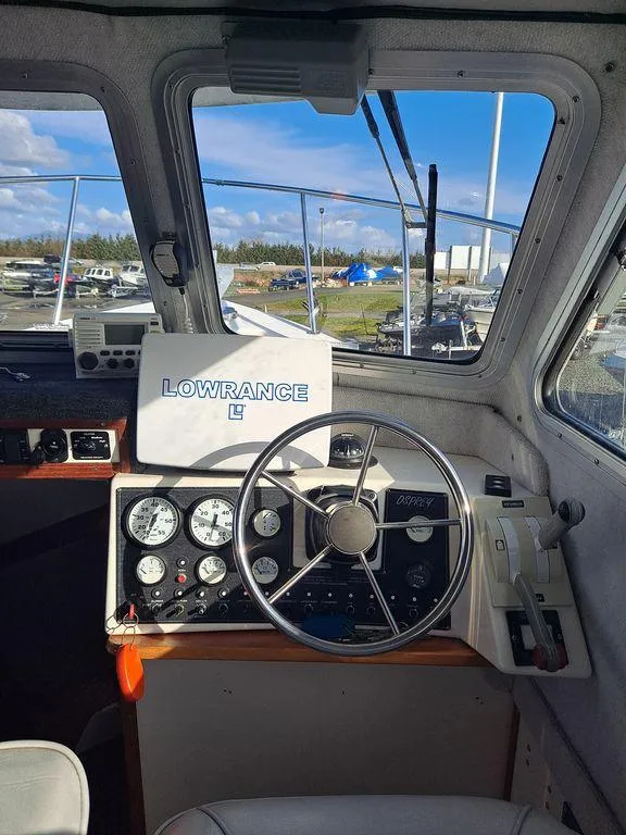 Slide: The Image of Interior view of a 2000 Osprey 26 Fisherman boat with steering wheel and navigation equipment. - 7