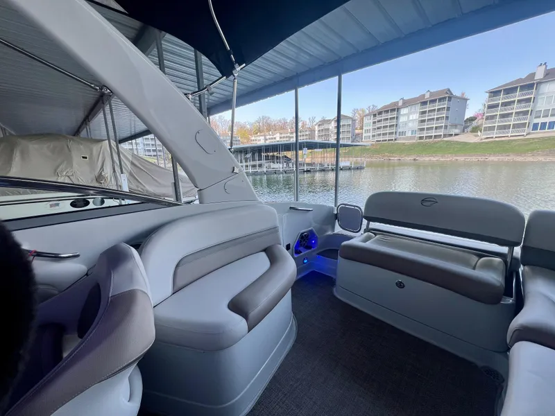 Slide: The Image of 2018 Crownline 285 SS boat interior with seating, docked by waterfront buildings. - 14