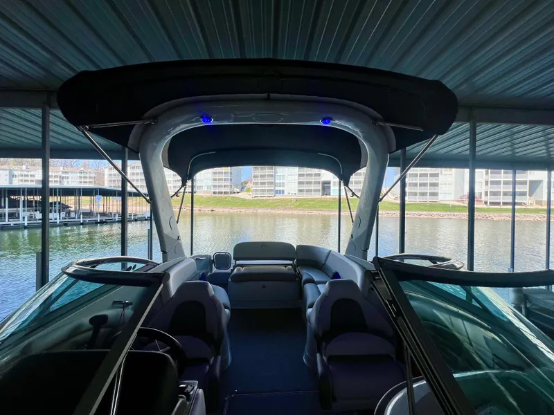 Slide: The Image of 2018 Crownline 285 SS boat interior under covered dock, featuring spacious seating and modern design. - 15