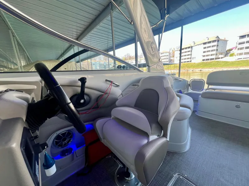 Slide: The Image of 2018 Crownline 285 SS boat interior with steering wheel and seating under a canopy. - 19