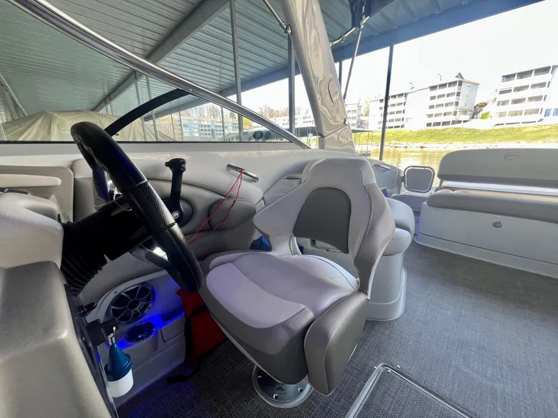 Slide: The Image of 2018 Crownline 285 SS boat interior with modern helm and seating under a covered dock. - 20
