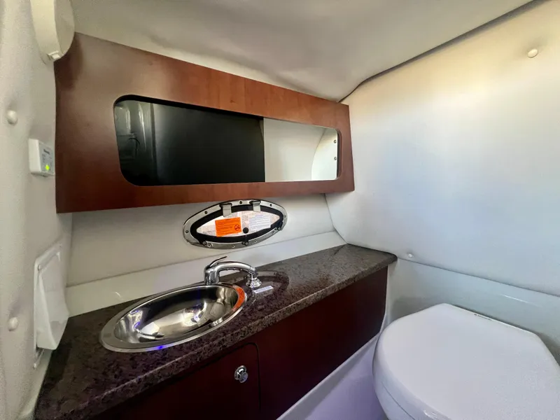 Slide: The Image of 2018 Crownline 285 SS boat bathroom with sink, mirror, and toilet. - 26