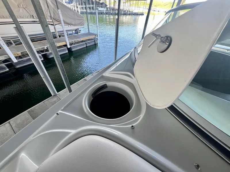 Slide: The Image of 2018 Crownline 285 SS boat with open storage compartment, docked at marina. - 28