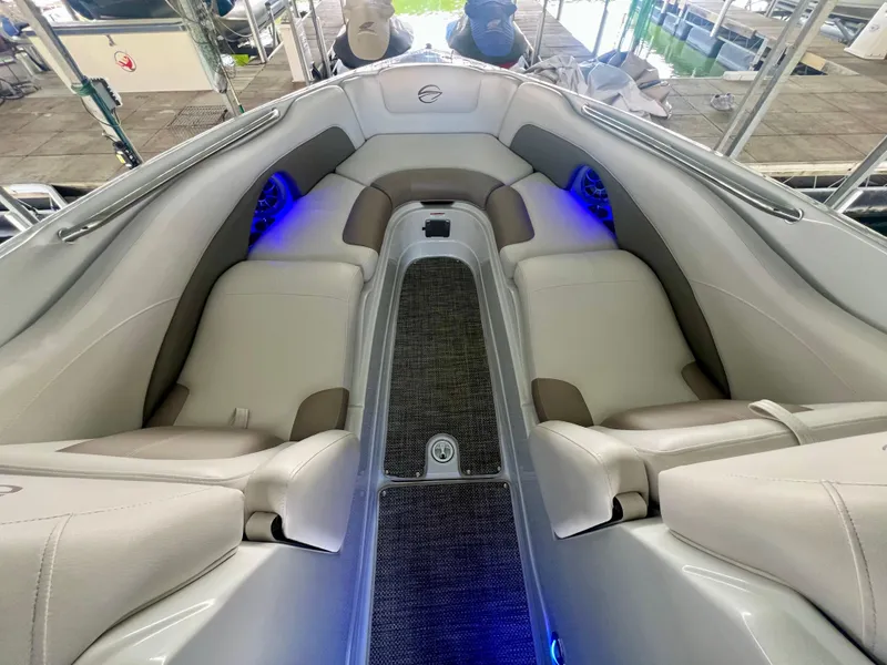 Slide: The Image of 2018 Crownline 285 SS boat interior with plush seating and ambient blue lighting. - 29