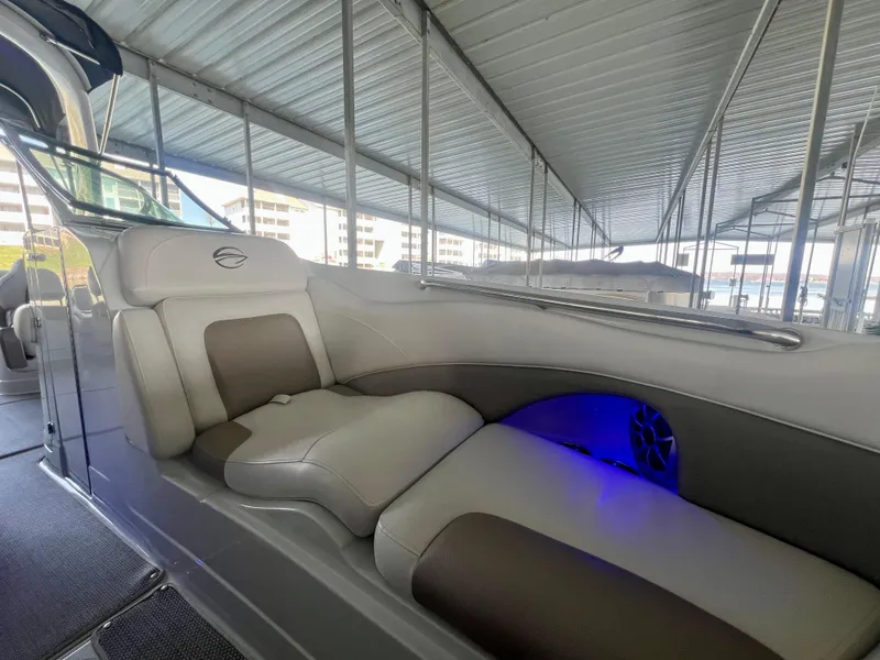 Slide: The Image of 2018 Crownline 285 SS boat interior with cushioned seating and blue LED lighting. - 30