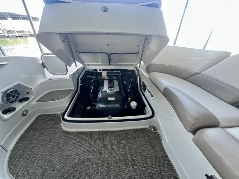Slide: The Image of 2018 Crownline 285 SS boat engine compartment with open hatch, revealing engine details. - 35