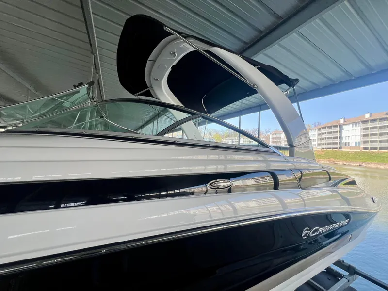 Slide: The Image of 2018 Crownline 285 SS boat under a covered dock, showcasing sleek design and modern features. - 4