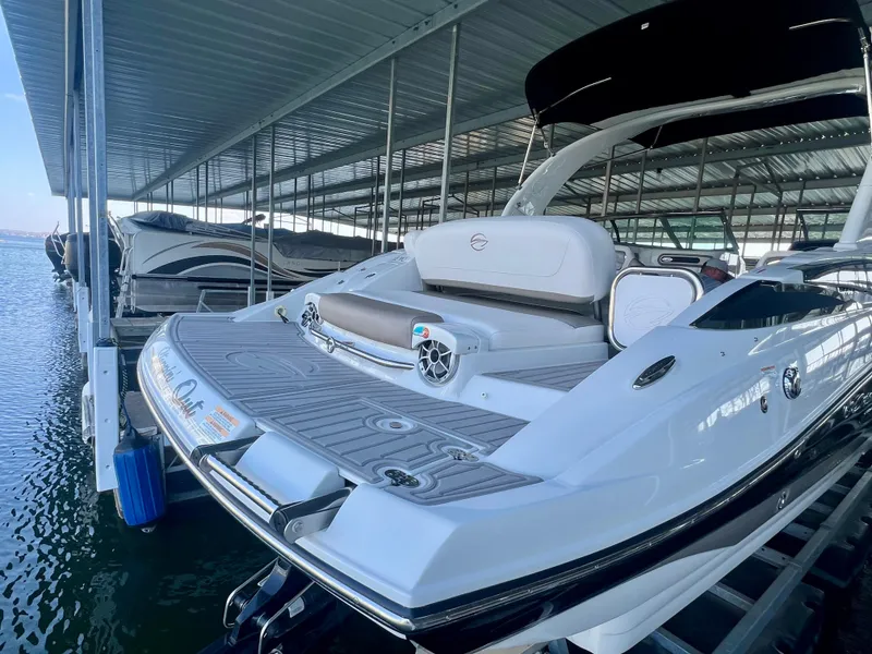 Slide: The Image of 2018 Crownline 285 SS boat docked in a covered marina, rear view. - 6
