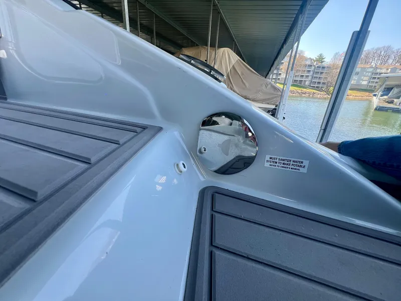 Slide: The Image of 2018 Crownline 285 SS boat interior with sleek design, docked near waterfront. - 8