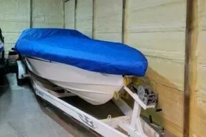 Slide: The Image of 2002 Profile 33 V boat with blue cover on trailer in garage. - 15