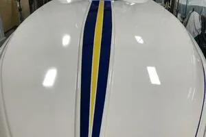 Slide: The Image of 2002 Profile 33 V boat with blue and yellow racing stripes on white hull. - 18