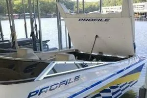 Slide: The Image of 2002 Profile 33 V boat docked, open engine hatch, lake background. - 2