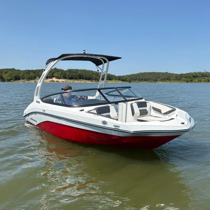 The Image of 2024 Yamaha Boats AR195 on a lake, featuring sleek red and white design. - 0