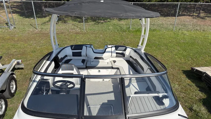 Slide: The Image of 2024 Yamaha Boats AR195 with open windshield and canopy, surrounded by trees. - 27