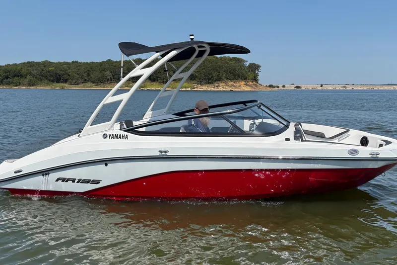 Slide: The Image of 2024 Yamaha AR195 boat on a lake, featuring sleek design and vibrant red hull. - 3