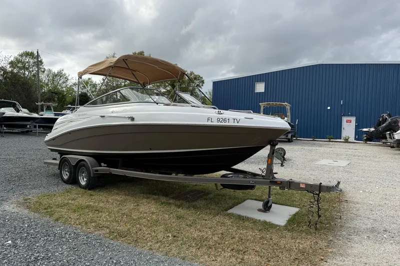 Slide: The Image of 2008 Yamaha Boats 232 Limited on trailer, parked outdoors near blue building. - 11