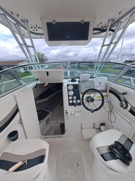 Slide: The Image of Interior view of a 2000 Seaswirl 2501 boat, featuring steering wheel and control panel. - 10