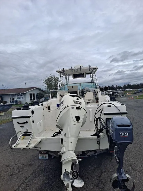 Slide: The Image of 2000 Seaswirl 2501 boat with dual outboard motors, parked on a cloudy day. - 2