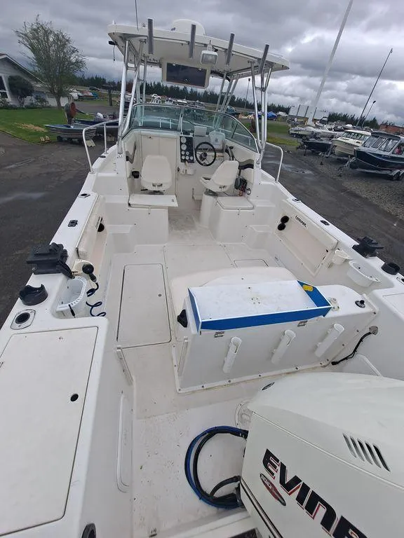 Slide: The Image of 2000 Seaswirl 2501 boat with Evinrude engine, spacious deck, and fishing setup. - 4
