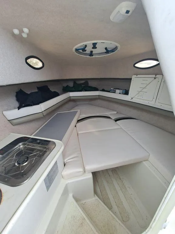 Slide: The Image of Interior of a 2000 Seaswirl 2501 boat with seating and a small kitchenette. - 5