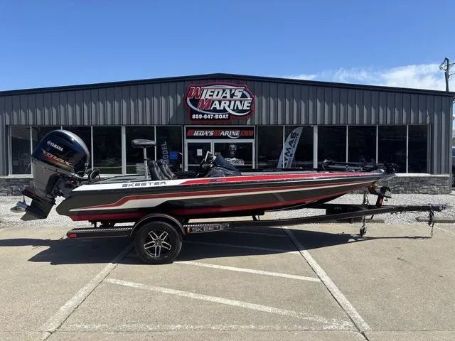 Slide: The Image of 2022 Skeeter ZX150 boat on trailer outside dealership, sunny day. - 1