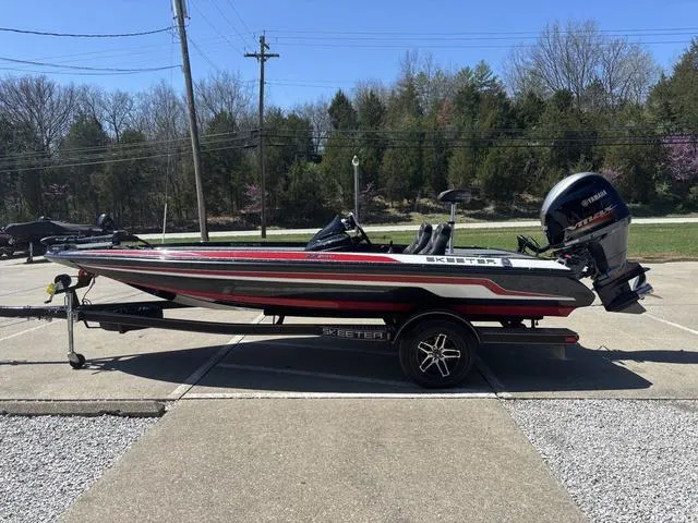 Slide: The Image of 2022 Skeeter ZX150 boat on trailer, parked outdoors, with Yamaha outboard motor. - 14