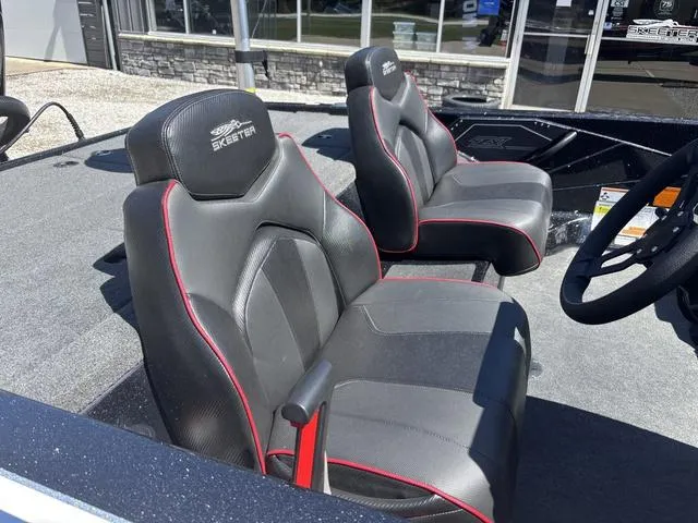 Slide: The Image of 2022 Skeeter ZX150 boat seats with black and red accents, outdoor showroom display. - 6