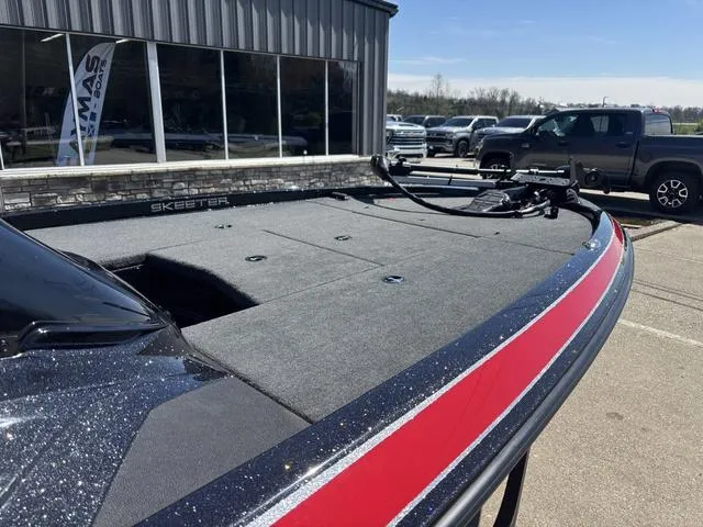 Slide: The Image of 2022 Skeeter ZX150 boat with red accents, parked outside a dealership. - 7