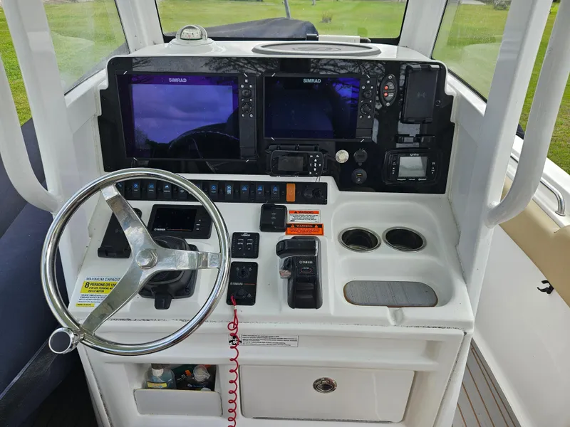 Slide: The Image of 2018 Sea Hunt Ultra 235 SE boat dashboard with steering wheel and navigation controls. - 5